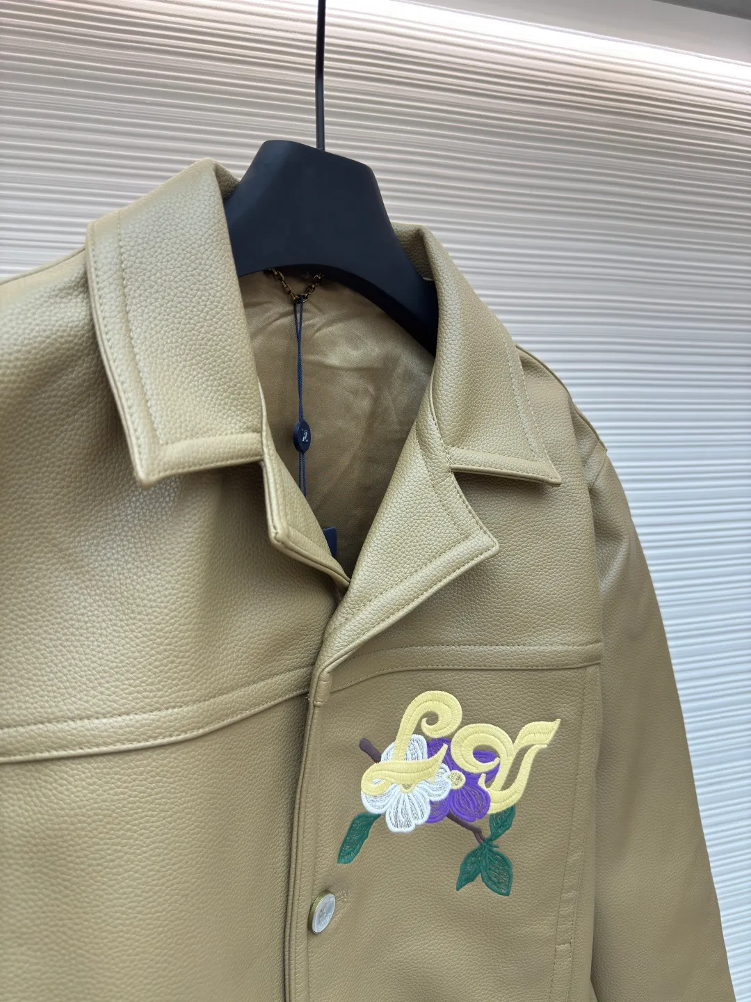 LOUIS VUITTON Tunic Jacket ●Authentic product: Purchased and developed by 50050 ●Item number: 1680165-C00 ●Fabric: Leather fabric ●Technology: Positioning cutting machine ●Version: Fitted version ●Weight: about 1365 grams ●Size: 50-52-54-56 ●Description: 24ss new tunic jacket has the retro connotation of gorgeous grain leather, with LV Flower Embroidery interprets seasonal tropical island elements. Marque L. Vuitton déposée leather patch sits at the back, and pearlescent buttons add a chic touch. The overall workmanship is very complicated. The embroidery is made with heat-capacitive glue, which needs to be ironed to ensure quality. The checkerboard pattern needs to be positioned correctly, so it is very fast. Each process of the entire garment is slow and time-consuming.